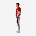 Side view of red and white club football uniform showing white set-in sleeve panel on jersey and red and black outer leg stripe on pants