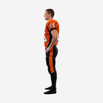 Side view of custom orange and black football uniform for leagues showing black side panel on jersey and bold orange outer-leg stripe running full length of black football pants
