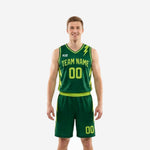 Custom forest green basketball uniforms with neon yellow-green lightning bolt side panels, arced team name and number on the jersey front, matching shorts