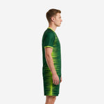 Left side view of men's forest green and lime green sublimated soccer uniform kit showing continuous spike pattern across jersey and shorts