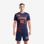 Full print custom men's soccer uniforms in navy blue and orange lightning design, front view of complete jersey and shorts set