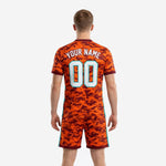 Back view of full print custom orange soccer uniform showing custom name and number on Maroon camo jersey and matching shorts