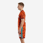 Men's custom orange soccer uniform with Maroon camo print and teal accent stripe, side profile view