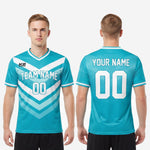 Flat lay of custom soccer tops in teal and white showing full chevron sublimation coverage