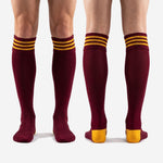 Full print custom maroon and Athletic Gold team soccer socks pair laid flat