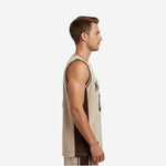 Custom tan and brown sublimated basketball jersey with crew neck binding and dark brown side panels, front view on adult male model
