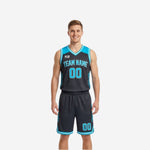 Full sublimation reversible basketball uniforms in charcoal with cyan yoke, arced team name, front number, and matching reversible charcoal shorts with cyan number