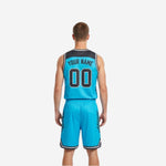 Side view of cyan sublimated reversible basketball jersey showing diagonal slash accent panels in charcoal and white armhole binding on the light side