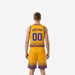 Gold side view of reversible basketball uniform showing gold base with purple hex-dot gradient pattern on jersey and shorts, male model