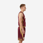 Adult male wearing custom burgundy basketball uniforms front view, arced team name and number 00 on maroon jersey with gold trim, matching gold waistband shorts