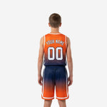Close detail of orange and navy gradient basketball shorts showing elastic waistband, drawcord, white side stripe, chevron hem cut, and front thigh number