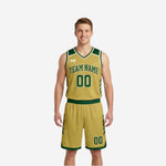 Front view of custom green and gold reversible basketball uniform with arched team name, front number, and angled gold slash accents on green jersey and shorts