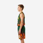 Side view of green and gold youth basketball uniform showing orange armhole binding, flame pattern rising up jersey hem, and matching green shorts