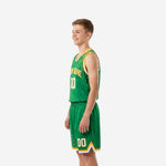 Side view of green and gold youth basketball jersey and shorts showing bound armhole trim and dot-splash side panel detail