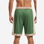 Opposite side view of custom green and white basketball shorts with chevron V-notch hem split and gold cream waistband stripe detail