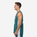 Side view of custom green basketball jersey showing teal front panel and white side panel construction with straight hem length