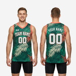 Back view of green basketball jersey showing back player name across shoulders and large back number on tropical palm-leaf sublimated panel