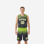 Green and black reversible basketball uniforms with hex-fade gradient showing dark charcoal front side and lime green reverse side on male model