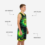 Detail view of custom black and green youth basketball shorts showing starburst sublimation, elastic waistband, player number, and neon hem trim