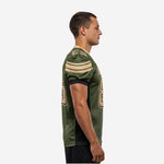 Green and gold custom football jersey side view showing set-in short sleeve with black cuff binding, gold shoulder cap stripes, and black mesh side panel running from armhole to straight hem