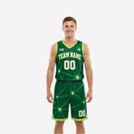 Green and white reversible basketball uniforms front view showing forest-green starburst geometric jersey and matching shorts on male model