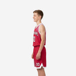 Side view of red and white halftone fade youth basketball uniform set showing armhole binding and shorts side panel detail