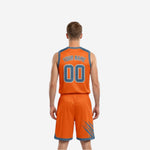 Orange and steel-blue reversible basketball uniform reverse side view displaying consistent slash-mark pattern across jersey and matching shorts