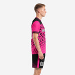 Left side view of hot pink black leopard print soccer kit showing sleeve cuff detail and pink side stripe on shorts