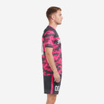 Side view of sublimated hot pink digital camo soccer kit with charcoal shorts and pink side stripe