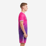 Side view of hot pink and royal purple gradient custom pink soccer uniform showing ombre fade from shoulder to hem on jersey and matching shorts