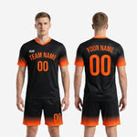 Full kit view of K2 Sportswear sublimated black soccer uniforms in Jet Black and Athletic Orange for men's club and league teams