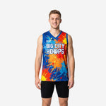 League basketball jerseys in royal blue with full-coverage orange and red paint-splash sublimation pattern, team name printed across the chest, front view on adult male model