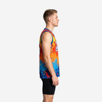 Side view of royal blue league basketball jersey showing orange and yellow paint-splash pattern, wide bound armholes, and tuck-in straight hem on adult male model