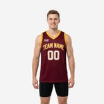 Maroon and gold basketball jerseys with arched team name front, gold V-neck binding, and white-outlined front number on a male model