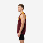 Side view of maroon and gold basketball jersey showing gold armhole binding, straight hem, and side vent on male model