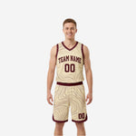 Custom maroon reversible basketball jersey front view with cream-gold V-neck binding, arched team name, and number 00 on a contour-pattern body
