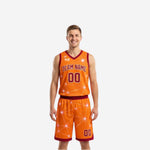 Orange side of the maroon and gold reversible basketball uniforms showing the team name arc and front number on the bright orange-dominant flip side