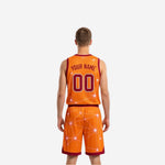 Opposite side view of the custom maroon and orange reversible basketball uniform showing the geometric starburst pattern across the shorts leg