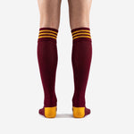 Close-up of Athletic Gold triple-stripe ribbed cuff on custom maroon over the calf soccer socks