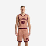 Blush side of the reversible basketball uniform set showing maroon topographic lines, arched team name, front number, and maroon V-neck binding