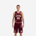 Reversible basketball uniforms with names and numbers in maroon, showing diagonal brush-stroke sublimation pattern and arced team name on the front of the jersey and shorts