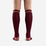 Close-up of ribbed cuff band on custom maroon knee-high soccer socks with rose-pink stripe detail