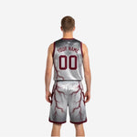 Side view of white reverse side reversible basketball uniform with maroon lightning pattern running from jersey through shorts