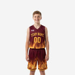 Front view of custom maroon youth basketball uniforms with gold flame sublimation pattern on jersey hem and matching shorts, team name and number 00 printed in gold