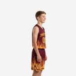 Side view of maroon and gold flame sublimation youth basketball uniform set showing V-neck jersey and matching shorts with chevron side panel accent