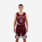 Maroon youth basketball uniforms front view showing white sweep graphics gold arced team name and matching shorts with curved leg design