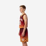 Left side view of custom boys basketball uniforms in maroon orange gradient showing hex pattern on jersey and shorts with gold trim detail