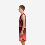 Side view of maroon youth basketball uniform set showing hex gradient from maroon shoulder to coral hem on jersey and shorts