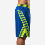 Side view of custom royal blue basketball shorts showing full X-shaped lime-green stripe wrapping the side panel and small hem split