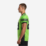 Left side view of the custom green and black American football jersey showing the sleeve cap stripe pattern and athletic fit
